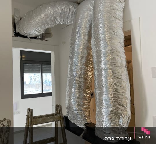 צינורות גמישים מכוסים בנייר כסף מותקנים בתקרה